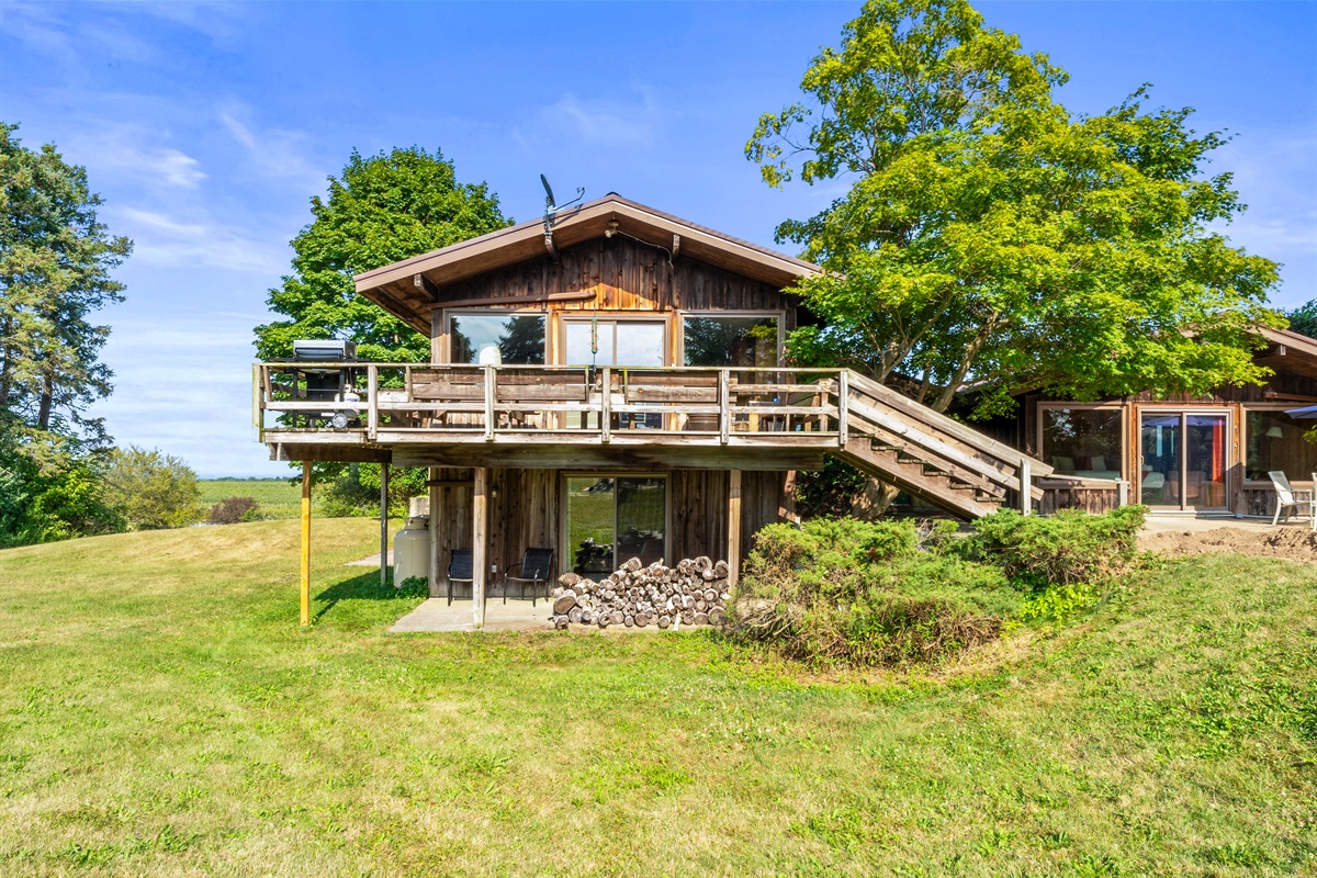 Rustic charm meets open skies at this countryside retreat! Featuring a spacious deck, floor-to-ceiling windows, and natural wood siding, this home is perfect for enjoying panoramic views and peaceful living.