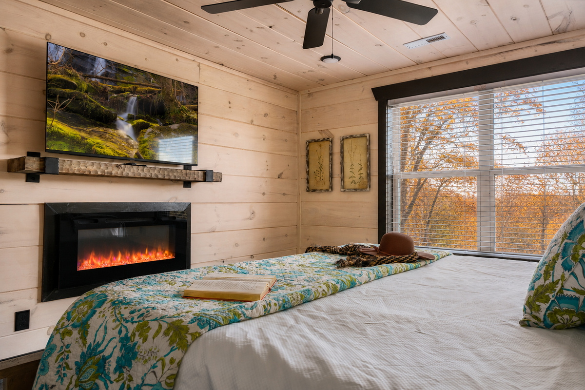 Upstairs primary suite features a king sized bed and electric fireplace.