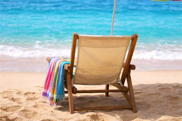 Where the waves whisper and the world slows down — just a chair, a splash of color, and endless ocean views