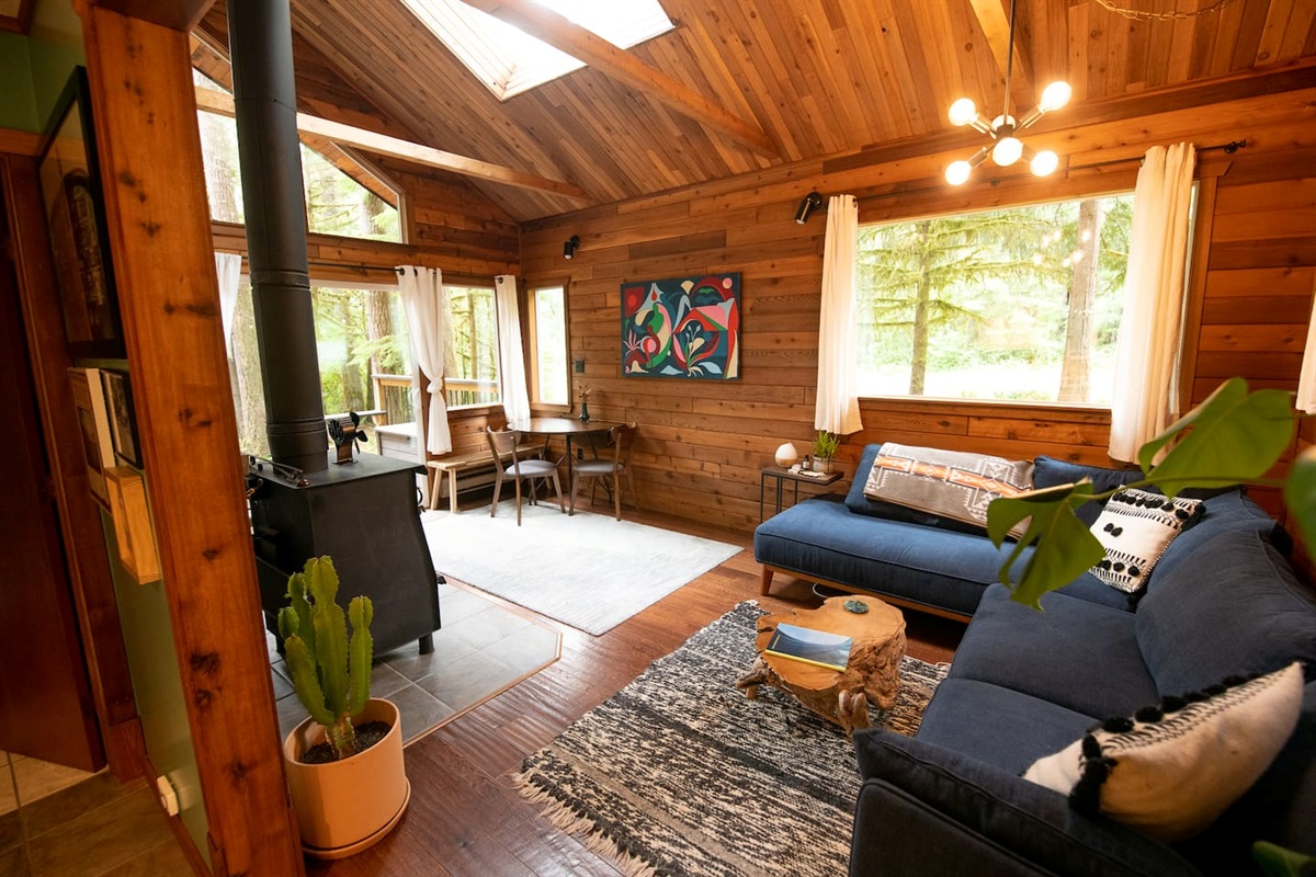 The living and dining room.  Enjoy the views of the cedar forest through the glass doors and windows.
