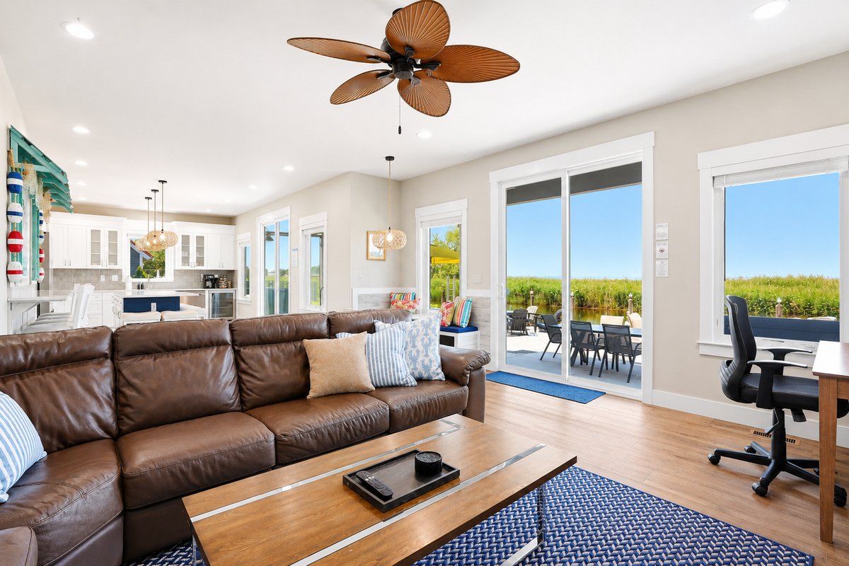 Relax in comfort with backyard and canal views just beyond the patio doors. This bright living space offers easy indoor-outdoor living, comfortable seating, and a dedicated workspace for those mixing work with vacation.