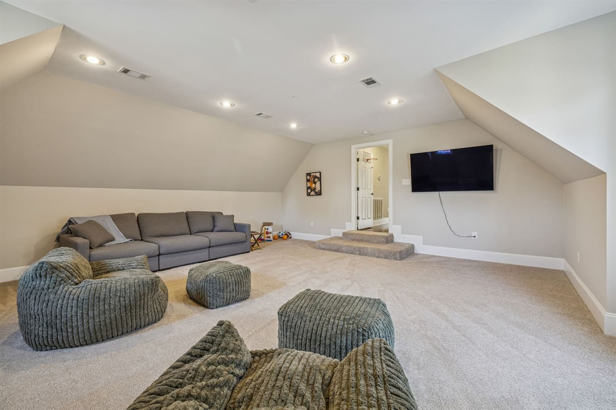 Upstairs Bonus room with a new TV, sofa, and two bean bag chairs 