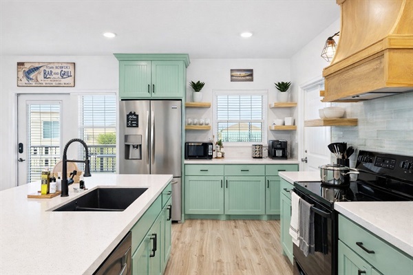 Kitchen (Main Floor): Seafoam cabinetry, stainless appliances, and a fully stocked setup for easy group meals.