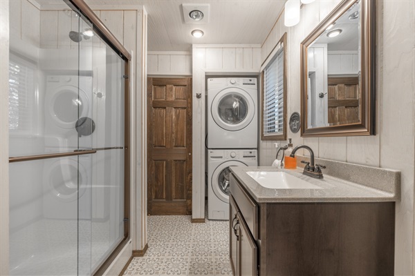 Main bathroom downstairs with walk in shower and washer/dryer