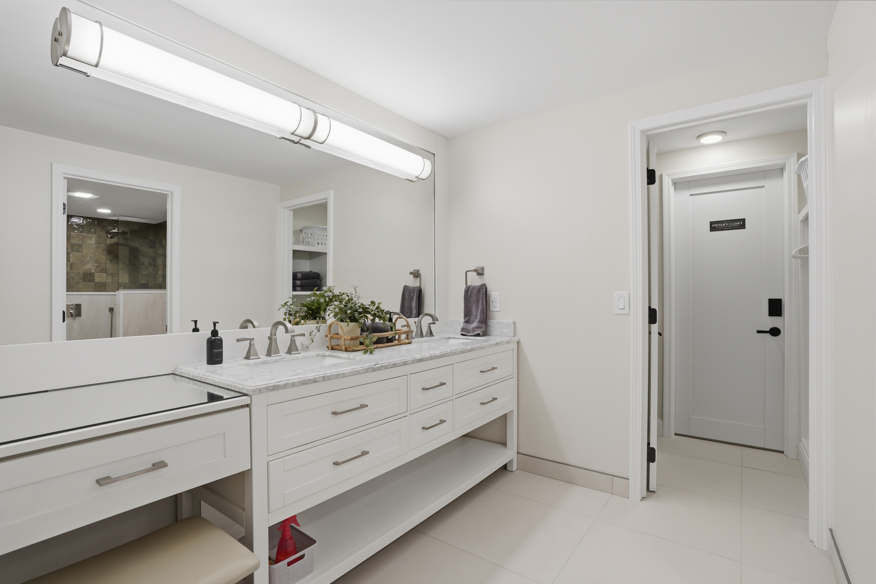 Bright, modern double vanity bathroom with quartz countertops, clean white cabinetry, and ample storage. Fresh, minimalist design with a hotel-like feel, perfect for a comfortable and elevated stay.