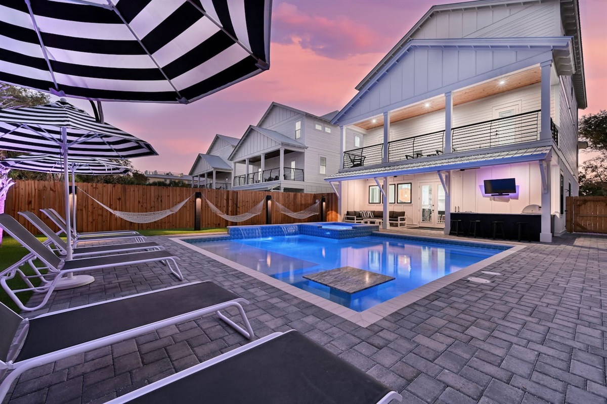 Astroturf yard with Luxury lounges, matching umbrellas, poolside hammocks, putting green, and (5) be