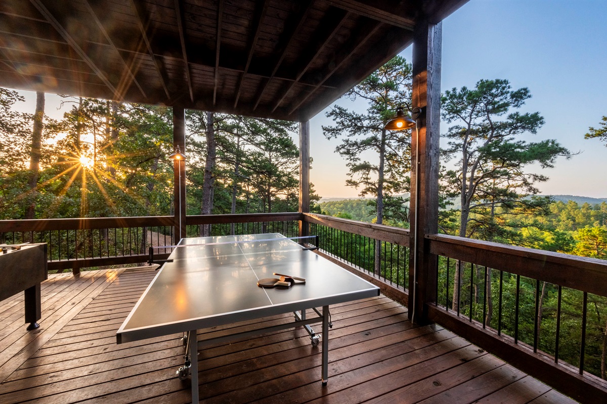 Outdoor entertainment area with ping pong table and stunning sunset scenery