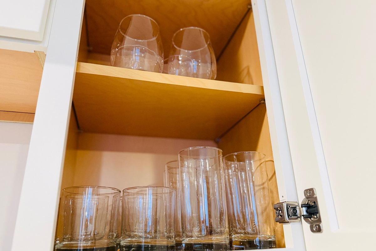 Kitchen cabinets include drinking glasses for guest use.