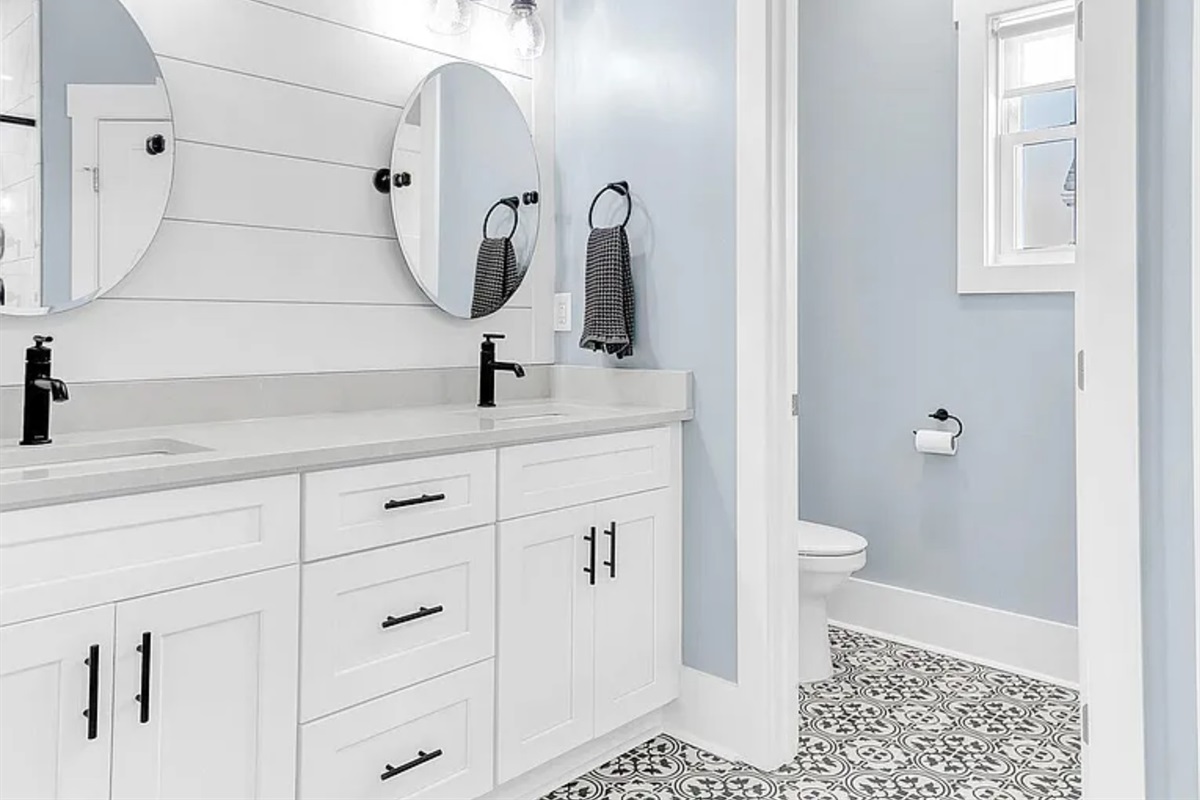 Bright primary bathroom with double vanity and modern finishes.