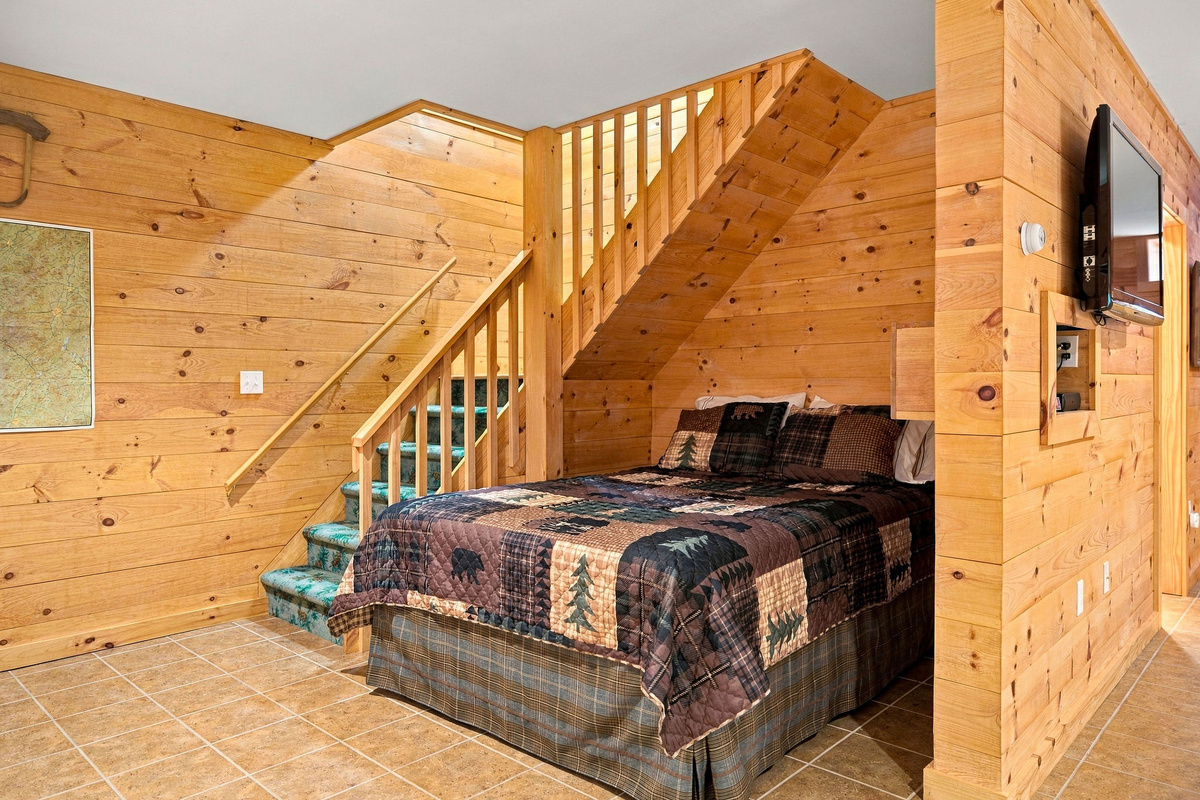 The open lower-level room has a queen bed for additional guests.