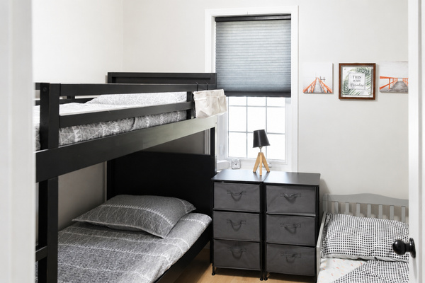 Family-friendly third bedroom featuring a twin bunk and toddler bed, suitable for both kids and adults.
