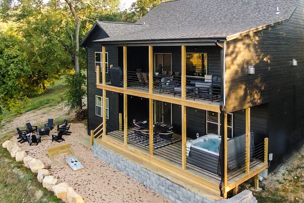 Rear elevation shows both decks, hot tub, fire pit, and more