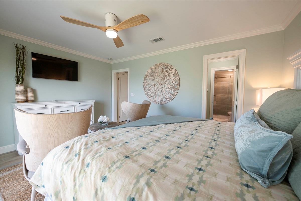 Relax in a serene bedroom with light green walls, modern decor, and a stylish ceiling fan.

