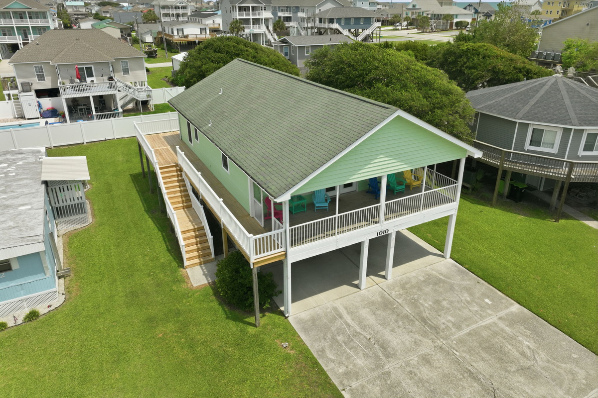Bird's-eye view highlighting the home's large lot, wraparound deck, and convenient beach location