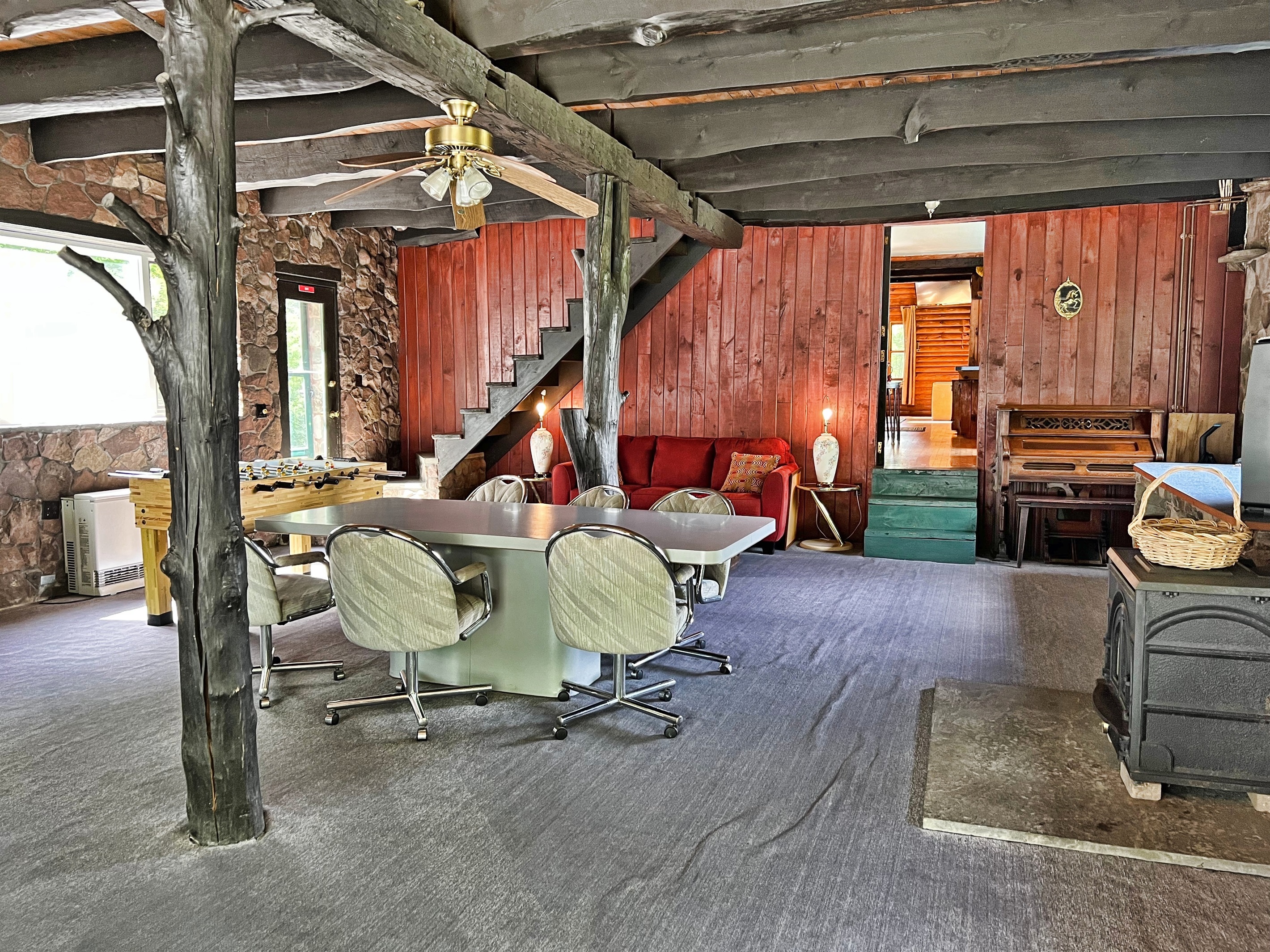 Great room with dining area and a piano! The green steps lead to kitchen. The back stairwell leads to the 2nd floor.