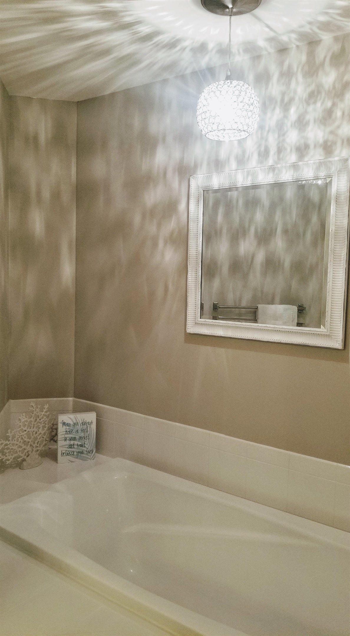 Decorative pendant light casts soft patterns across the ceiling, adding a warm, elegant glow to the space.