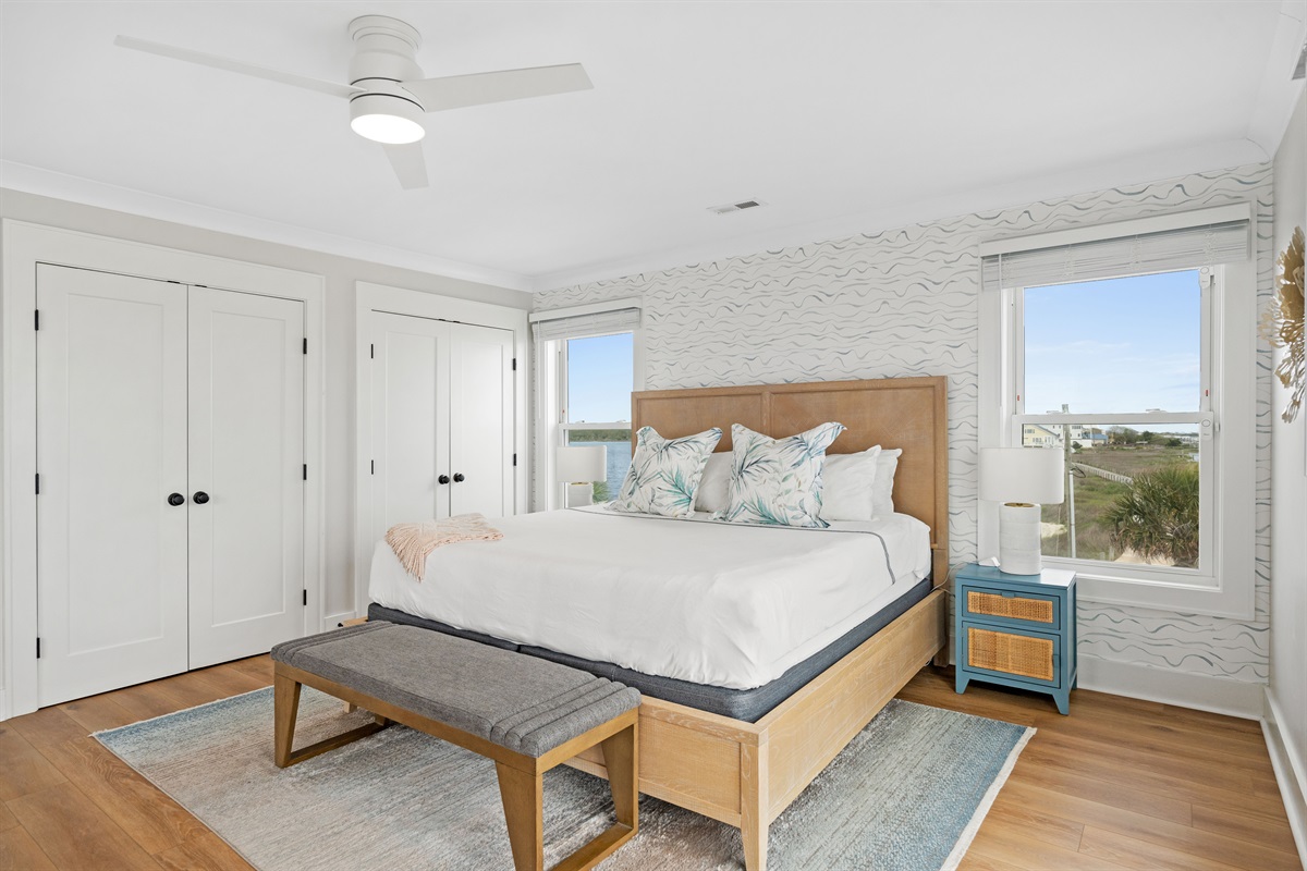 Elegant king suite with coastal-inspired d&eacute;cor and oversized windows for natural light