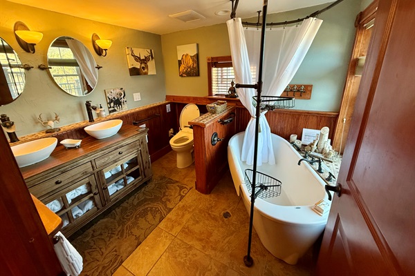 Spacious main bathroom with double sinks, soaking tub, and heated floors for cozy mountain mornings.