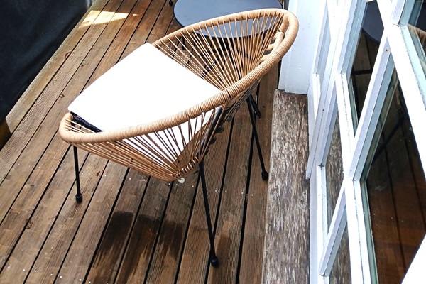 The Captain's private morning retreat. Step through the primary French doors to find your own bistro balcony—the only spot on the property to catch a glimpse of the ocean. This quiet perch overlooks the cedar-lined patio, offering the perfect hidden nook f