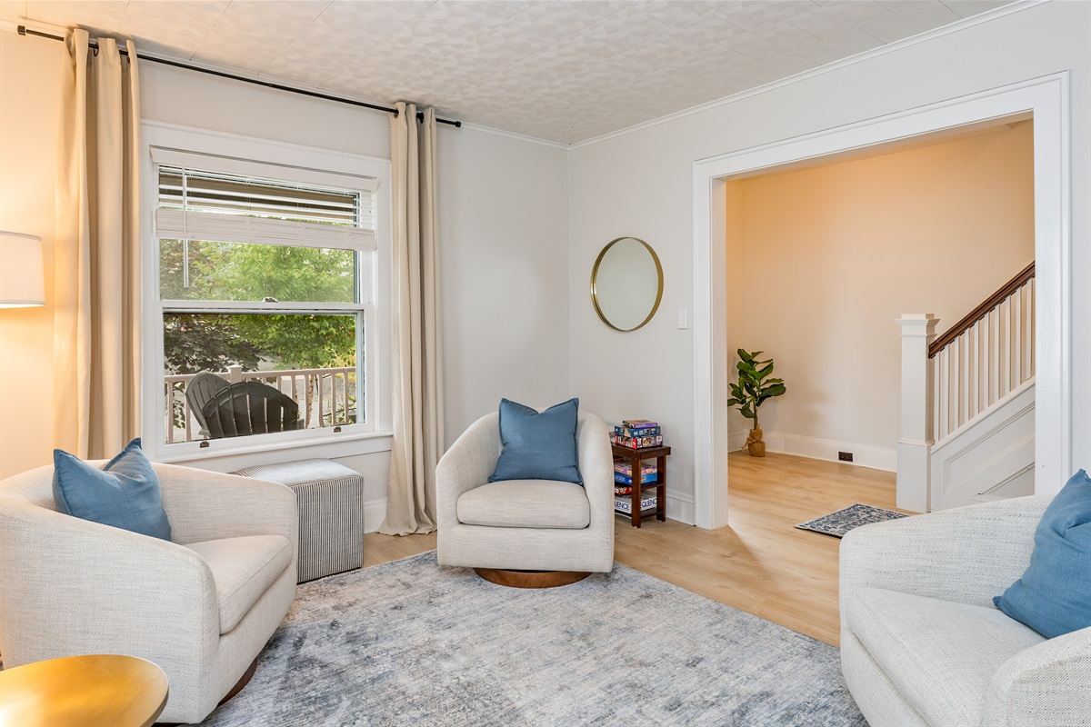 Enjoy morning coffee or a board game night in this sun-drenched living room with cozy swivel chairs and curated décor.