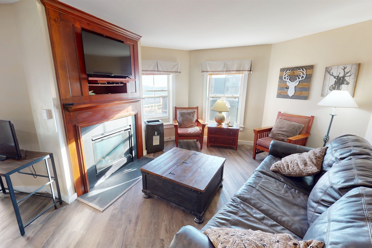 Cozy lodge living room with gas fireplace and big windows—your après-ski hangout.