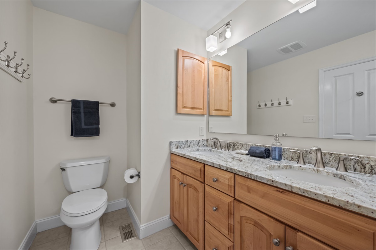 Spacious kids&rsquo; bathroom with granite vanity and full bath setup