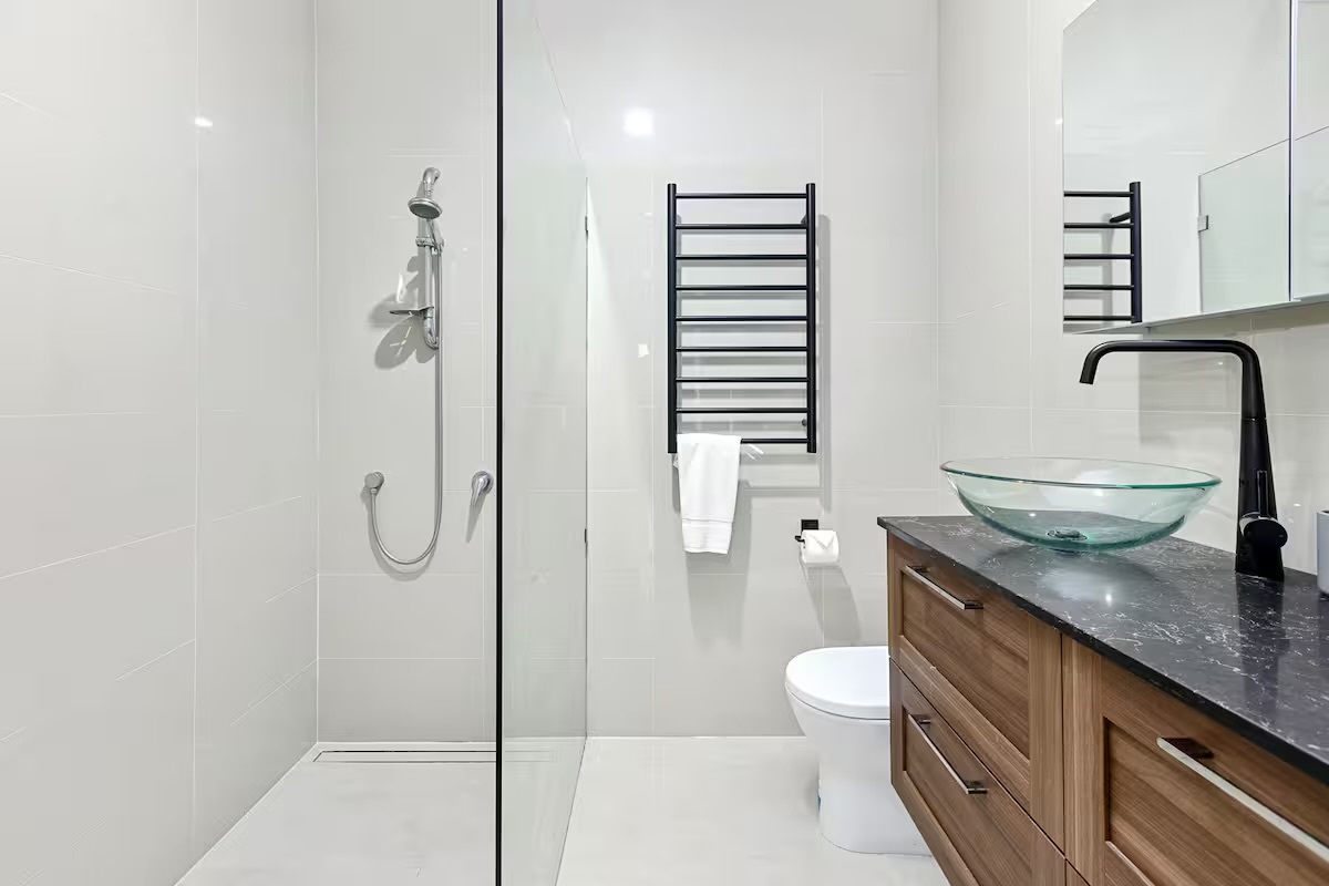 Clean finishes, a bright mirror area and practical layout give this bathroom at Sasha’s Cottage on the Hill a fresh everyday feel.