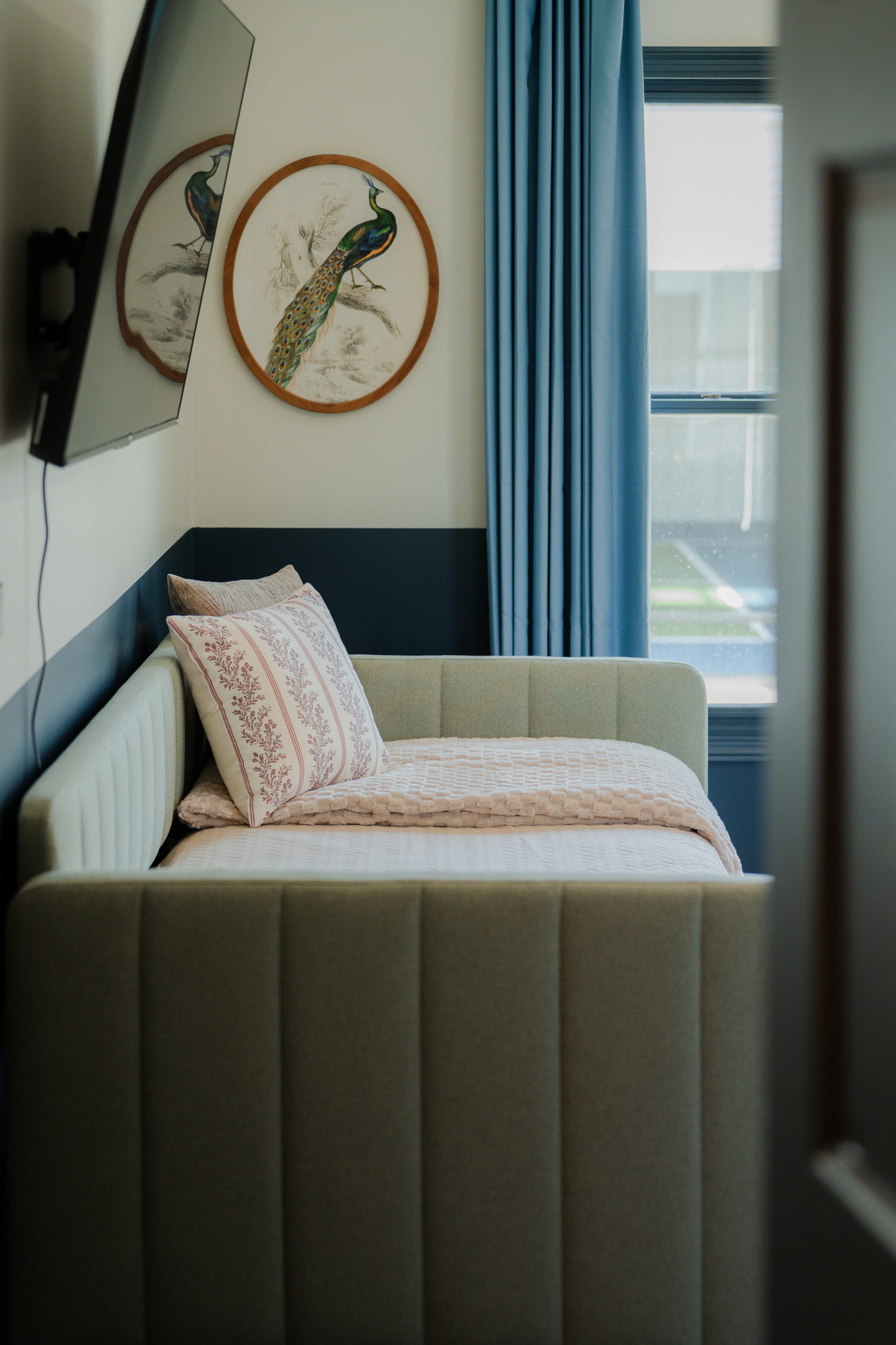A cozy sleeping nook complete with a twin bed and TV.