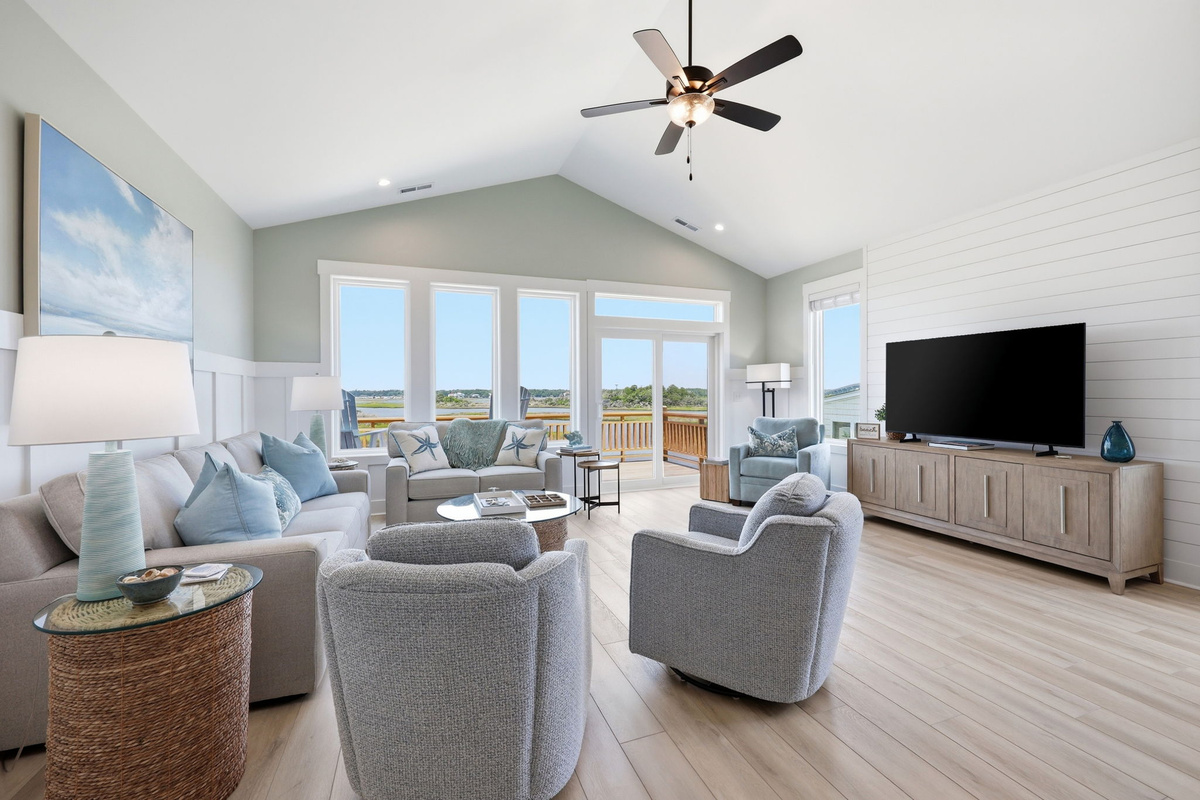 Gather together in this bright, open living room with soaring ceilings and beautiful sound views