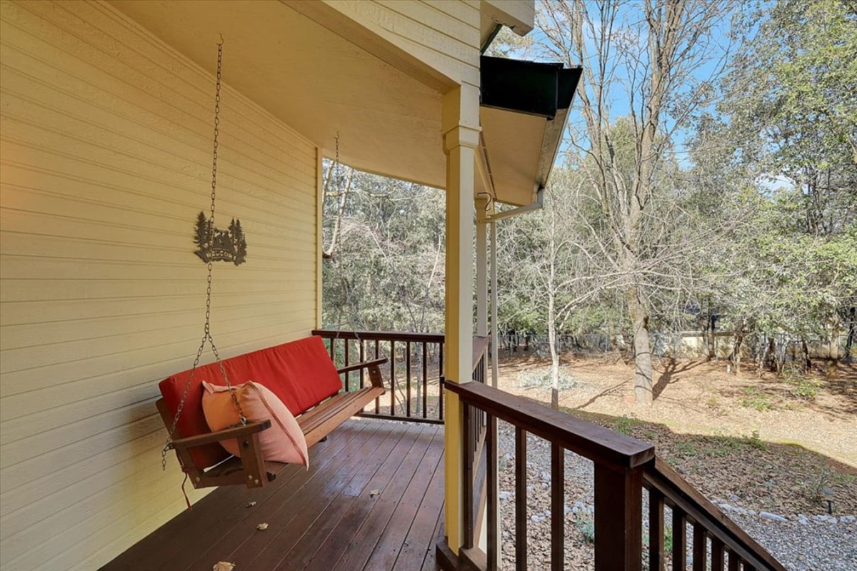 Covered porch swing with wooded views and a quiet spot to sit outside.

