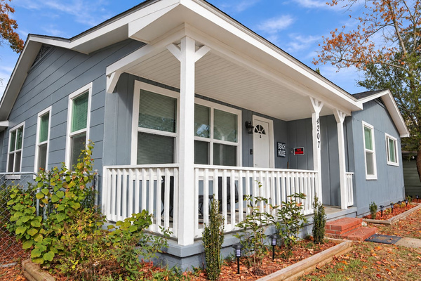 Charming Exterior: Embrace coastal living on the inviting porch of your beachside retreat!