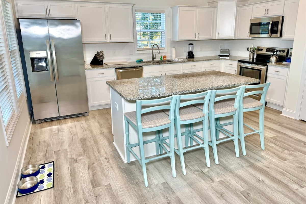 Enjoy cooking in this fully stocked kitchen with an island, bar seating, and a water view.