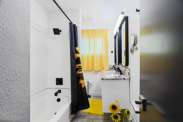 A stylish black and yellow bathroom featuring a luxurious bathtub for the ultimate relaxation and sophistication.