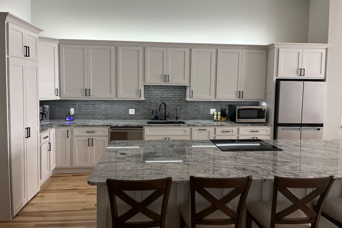 You will notice a small silver bar on the cabinet just left of the fridge. If you tap that bar it will turn on our under/over cabinet lights!  If you press and hold it the lights will dim.  If you press and hold it a second time they will brighten! 