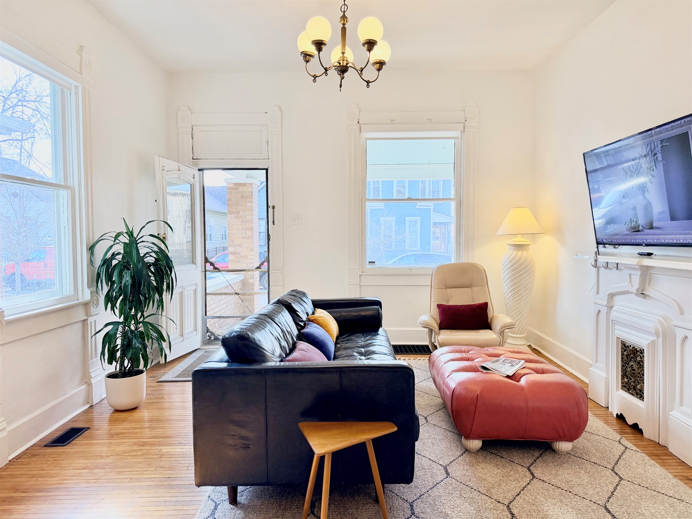 Full-length, deep-seated leather sofa facing a decorative fireplace and 55” Roku TV, with soft lighting, cozy blankets, and fast Wi-Fi for relaxed nights and easy st