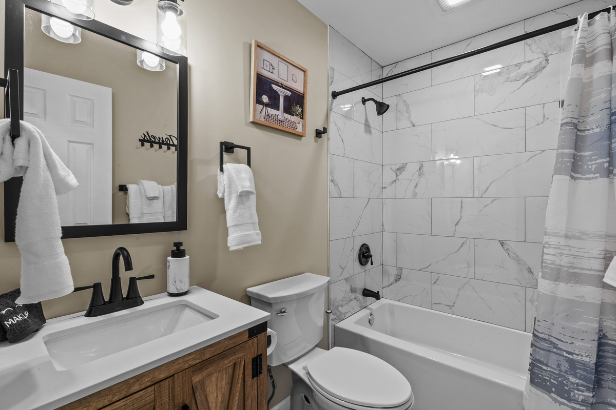 Steps away from the bunk rooms, this bathroom features a clean, bright layout with a full tub-and-shower combo.