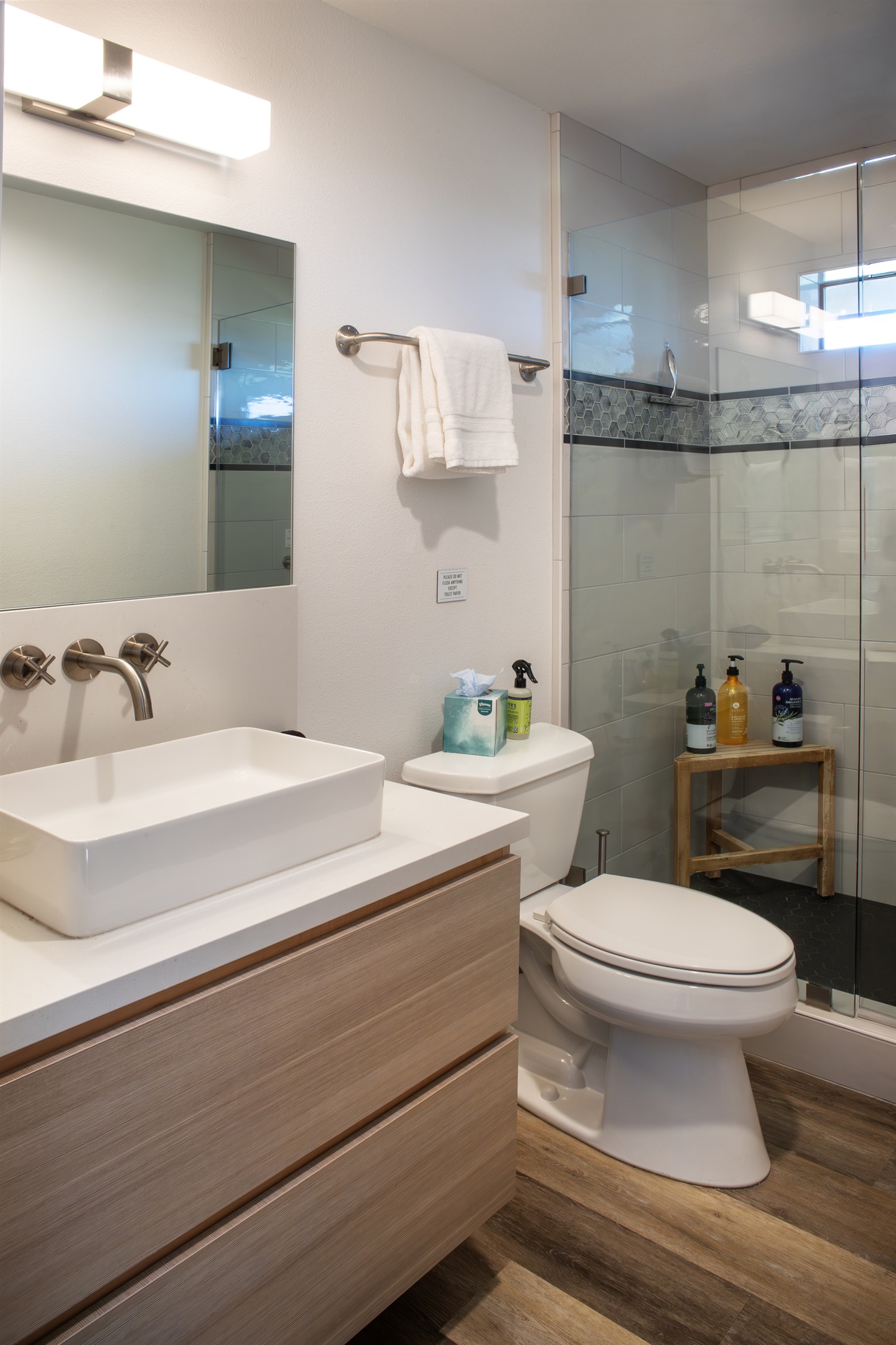 Modern fixtures, warm wood-look flooring, and a walk-in shower stocked with everything you need for the perfect refresh.