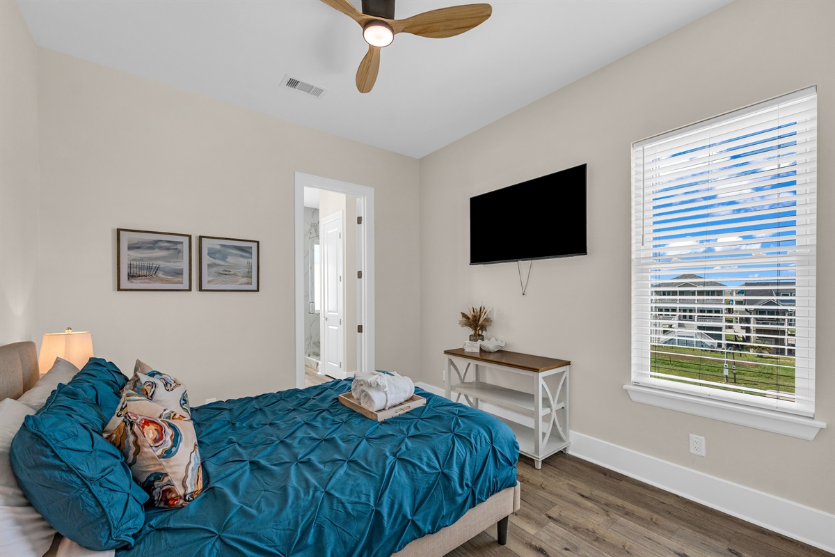 Costa Cristal Bedroom 5: Modern and comfortable bedroom featuring a neatly made bed, a wall-mounted TV, and a window that brings in plenty of light, creating a welcoming atmosphere.