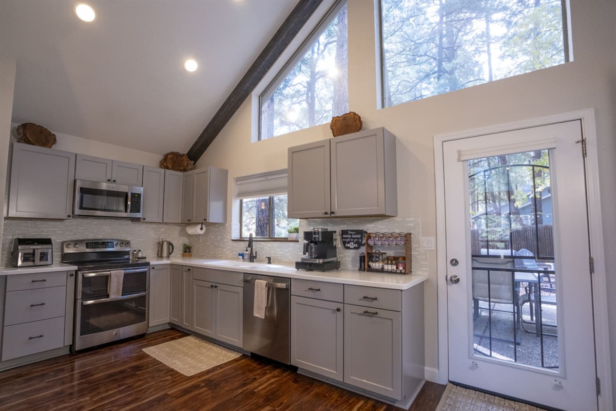 Bright kitchen with high ceilings, full-size appliances, and space for simple meals during your stay.