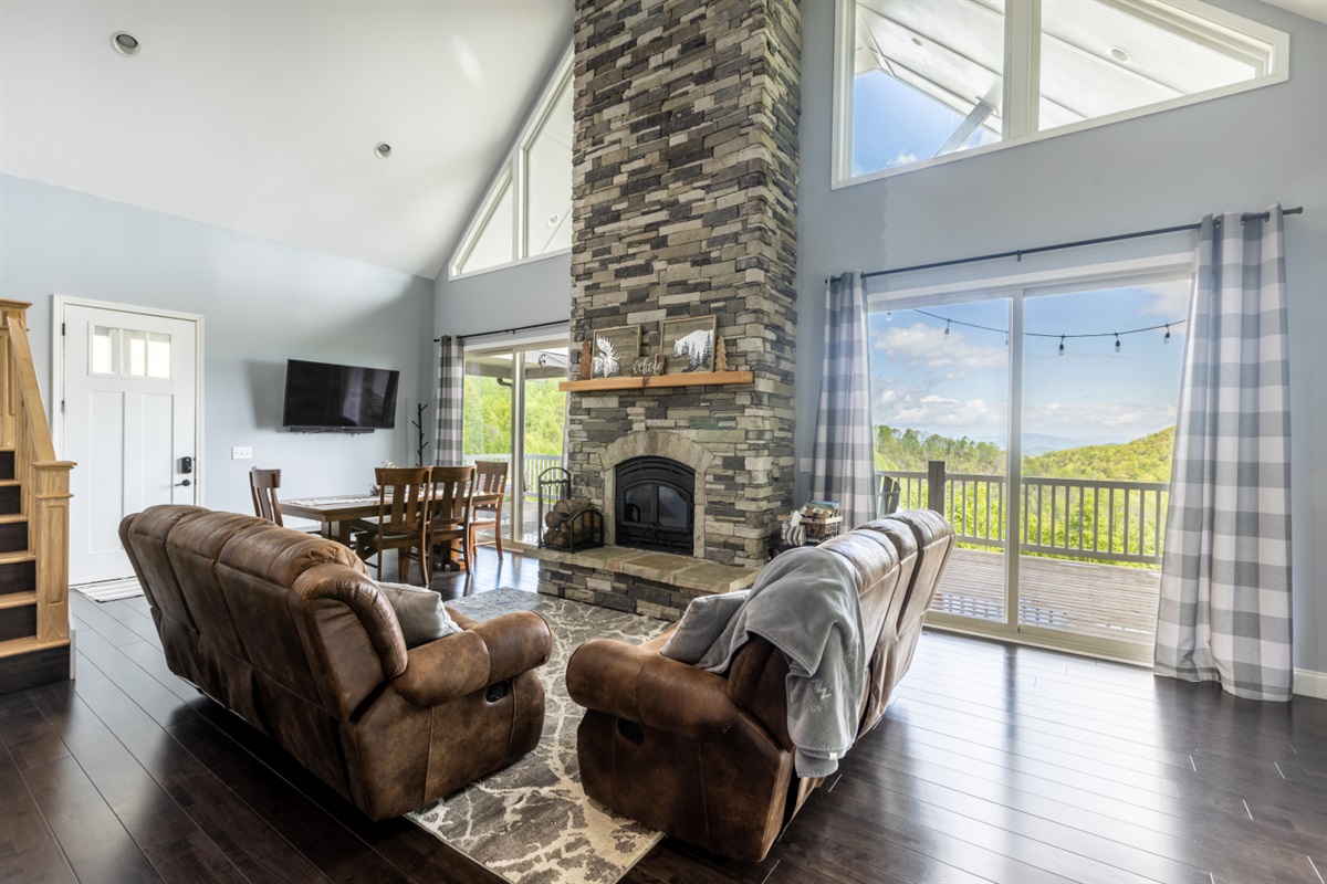 Cozy living room with a wood burning fireplace and stunning view of mountains