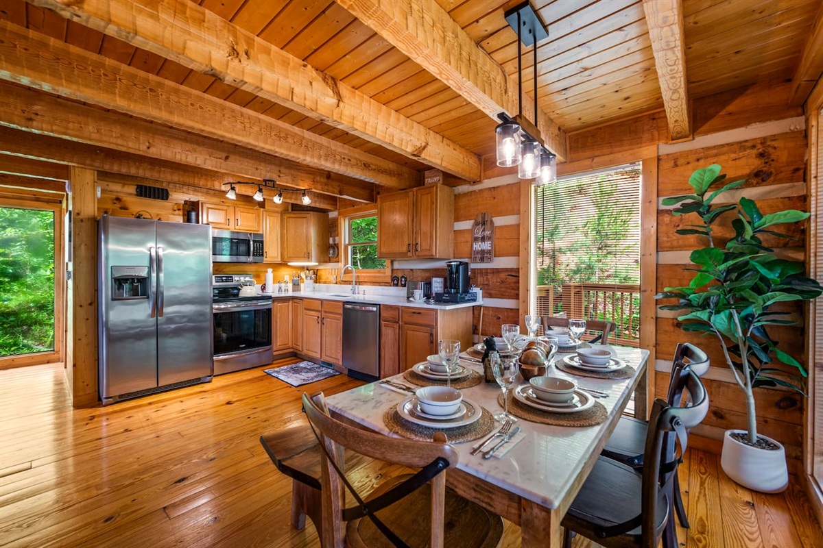 Cabin Kitchen. Wood walls and floors. Stainless still appliances. Marble countertop. Dinning table with marble top for 6 people. View to woods.