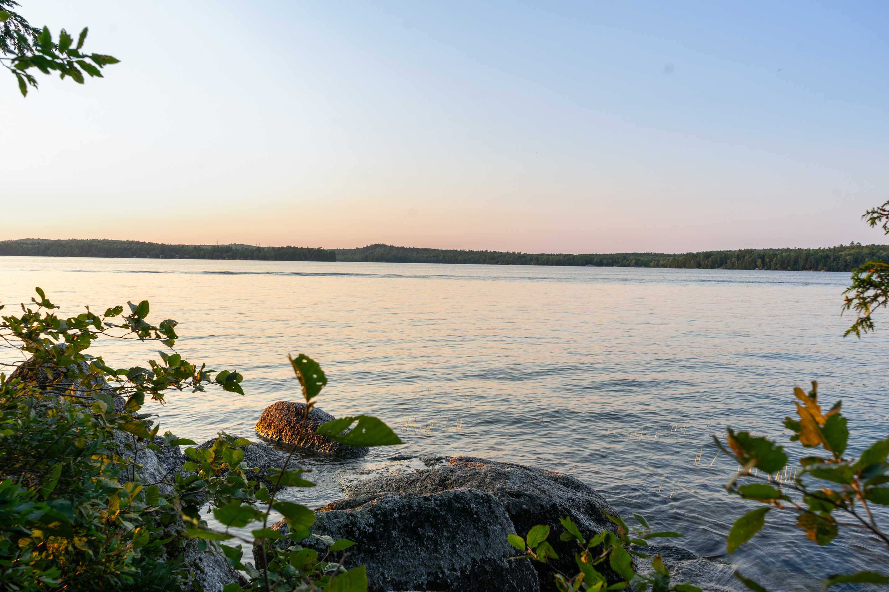 Waterline view off the front of Loonrise Point! Sunlit granite boulders and clear ripples look out over Beech Hill Pond in Otis, ME. Prime shore spot for watching loons, launching kayaks, or taking in quiet Maine sunsets, 20 mins to Ellsworth.