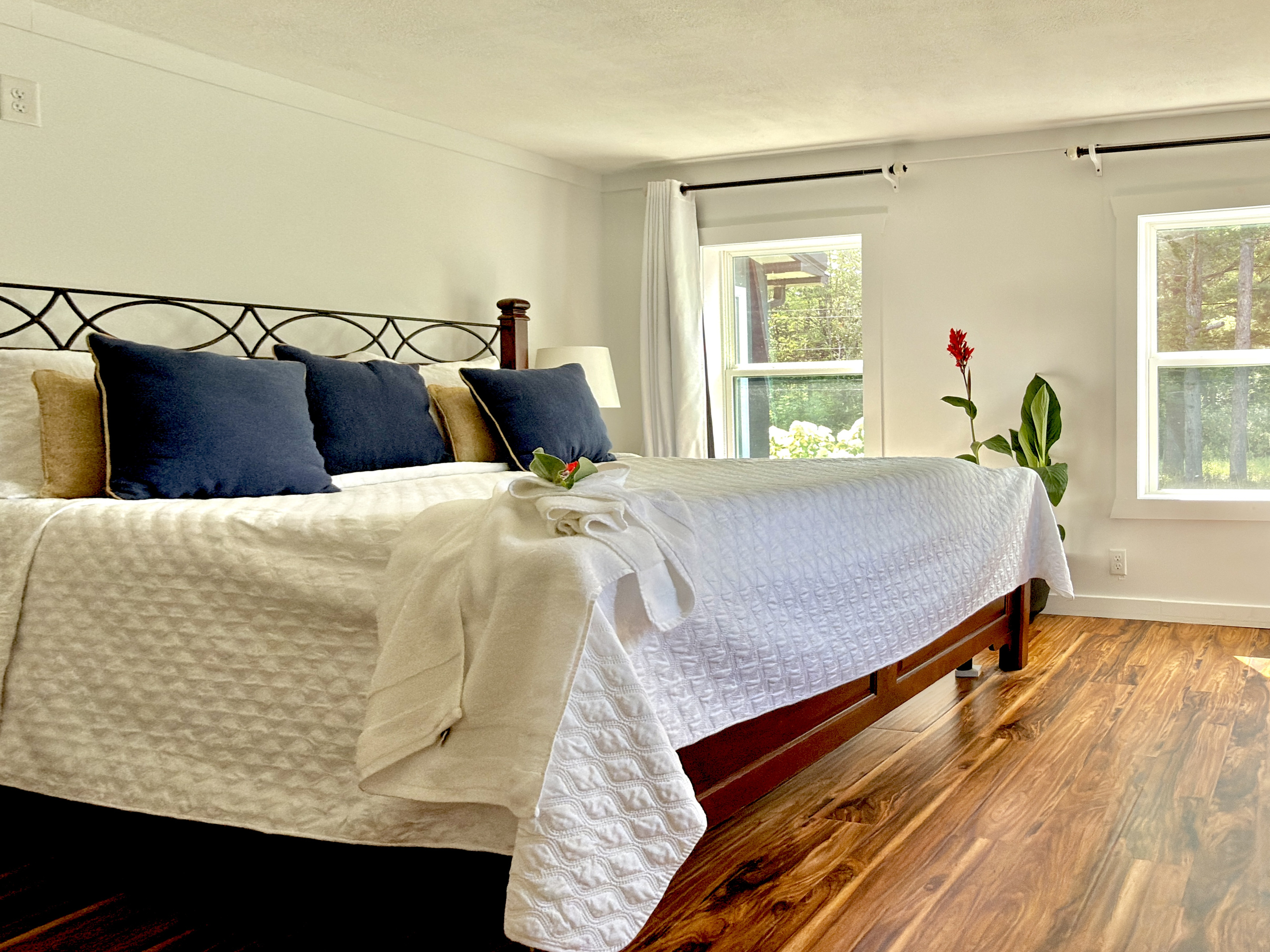Main floor bedroom featuring a premium California King-sized mattress, room-darkening shades, and a cozy Duraflame fireplace. A peaceful retreat for restorative sleep. Note: (Single) step down to bathroom via kitchen.