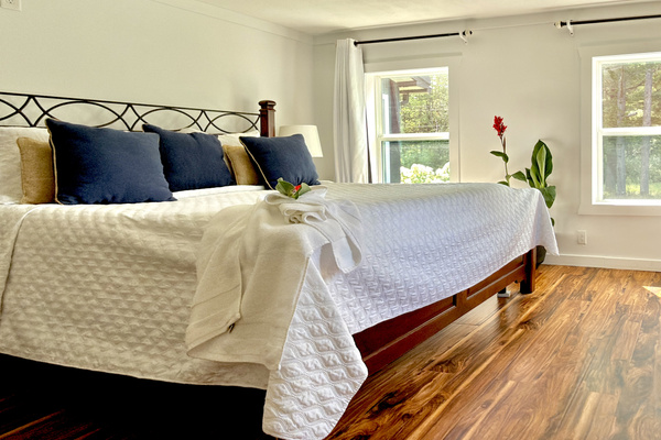 Main floor bedroom featuring a premium California King-sized mattress, room-darkening shades, and a cozy Duraflame fireplace. A peaceful retreat for restorative sleep. Note: (Single) step down to bathroom via kitchen.