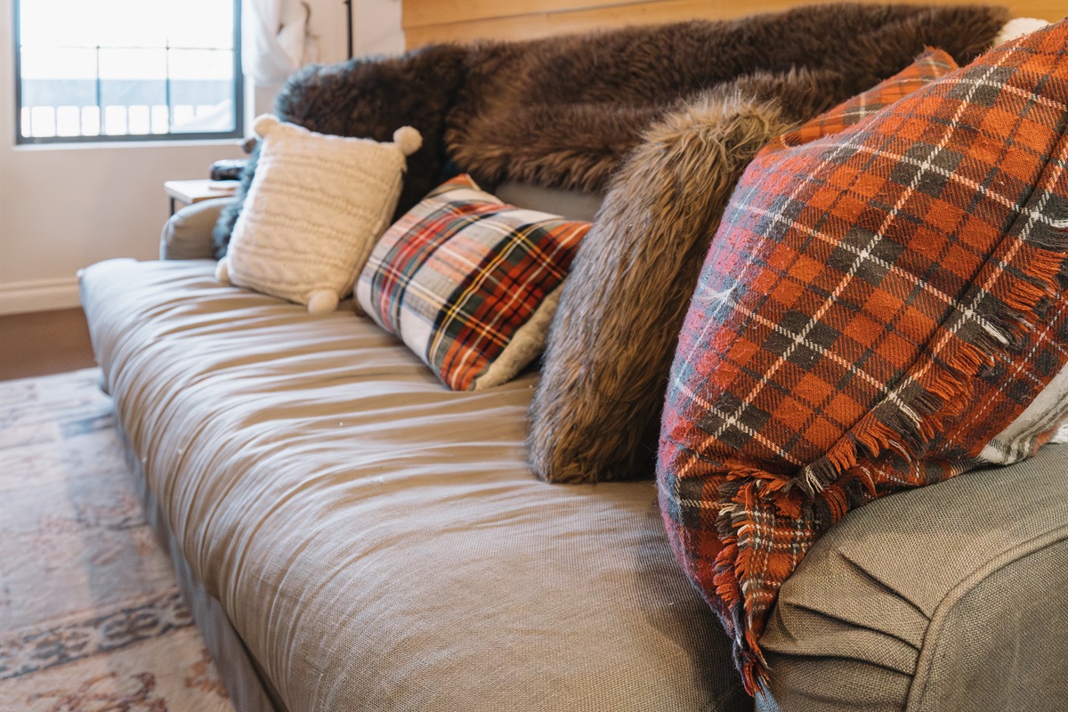 Cozy mountain living room with plush seating, warm wood accents, and surround sound—perfect for movie nights, relaxing after skiing, or slow evenings with loved ones.