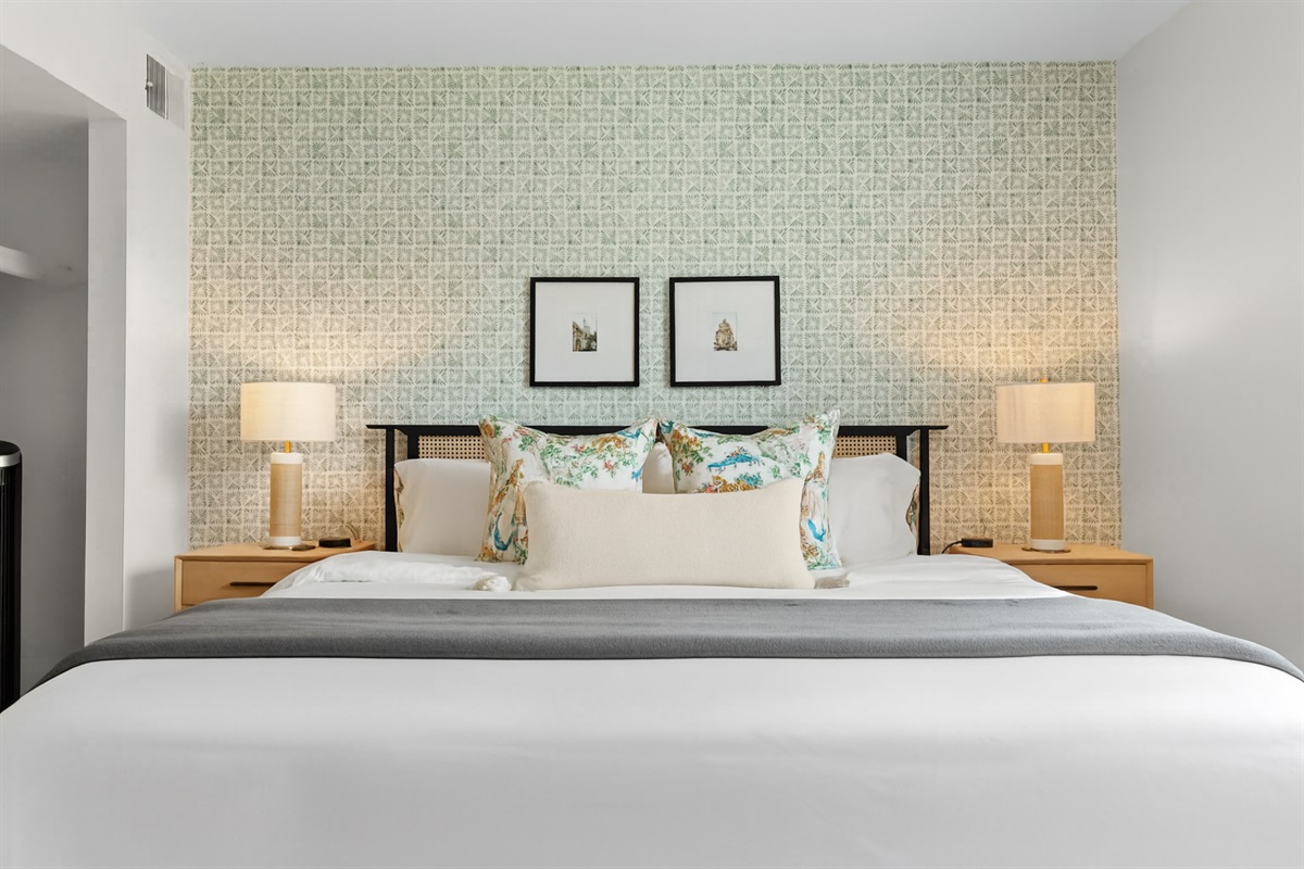 Bright and tranquil bedroom with accent wallpaper and a plush bed for a peaceful retreat.
