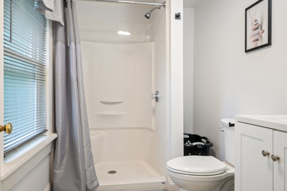 Wash up comfortably in our bright second-floor bathroom. Featuring a clean walk-in shower, white vanity, and a frosted privacy window that completely blocks views without losing natural light, this space serves the upstairs bedrooms perfectly.