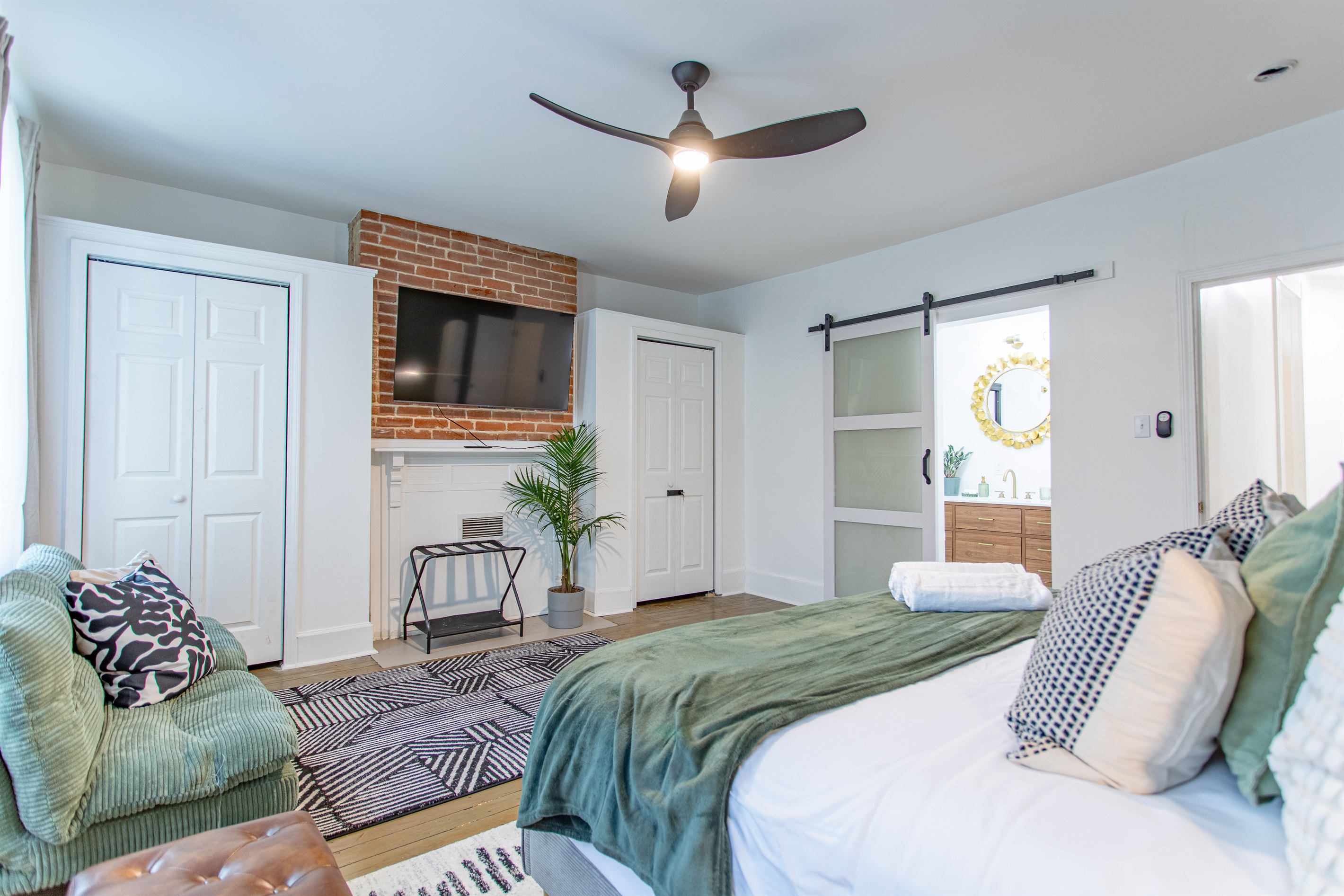 Master suite with king bed, twin futon, mounted TV, and private ensuite—blending comfort, function, and modern style