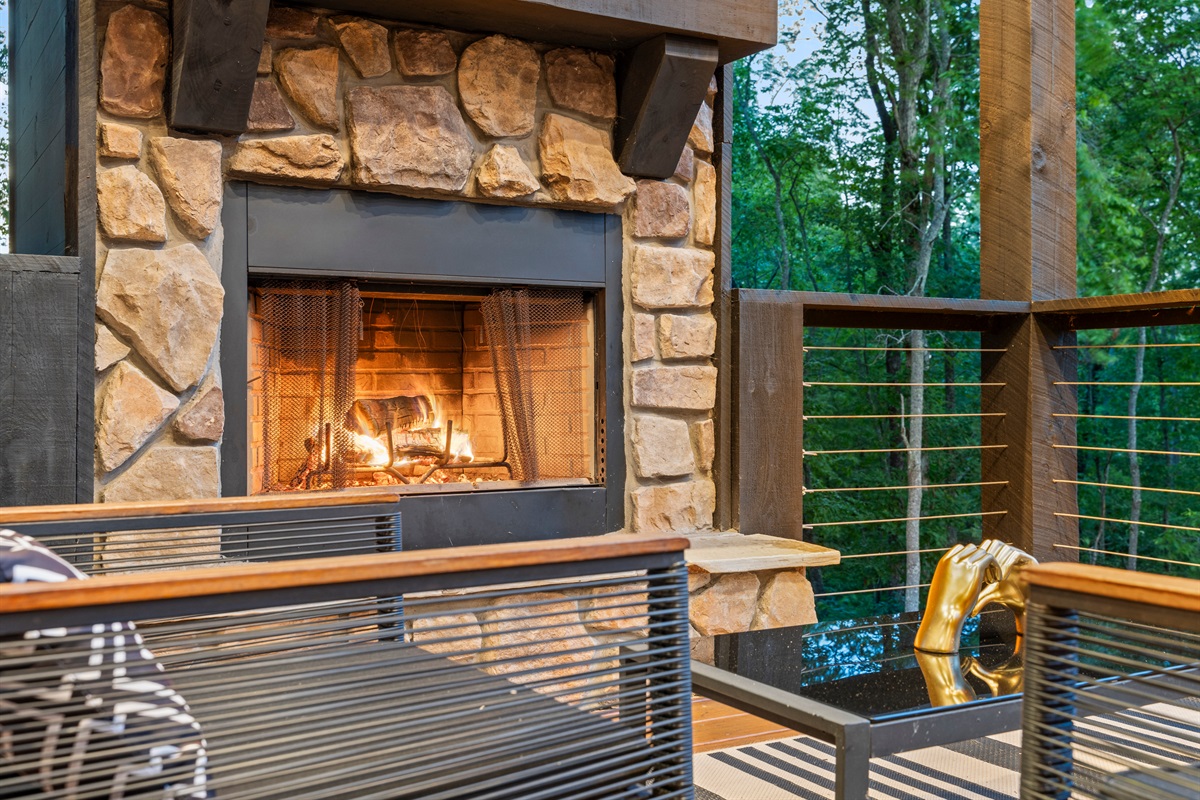 The stone fireplace anchors this outdoor seating area, providing a warm and inviting space to gather and relax.