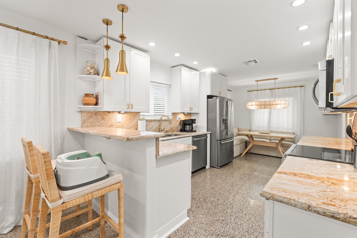 Cook, connect, and unwind in this beautifully updated kitchen with warm stone finishes and brass accents.